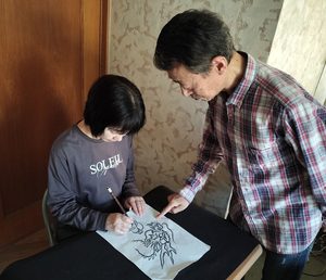 水墨龍画教室の指導イメージ。龍の絵を描く人に講師が描き方を説明している様子