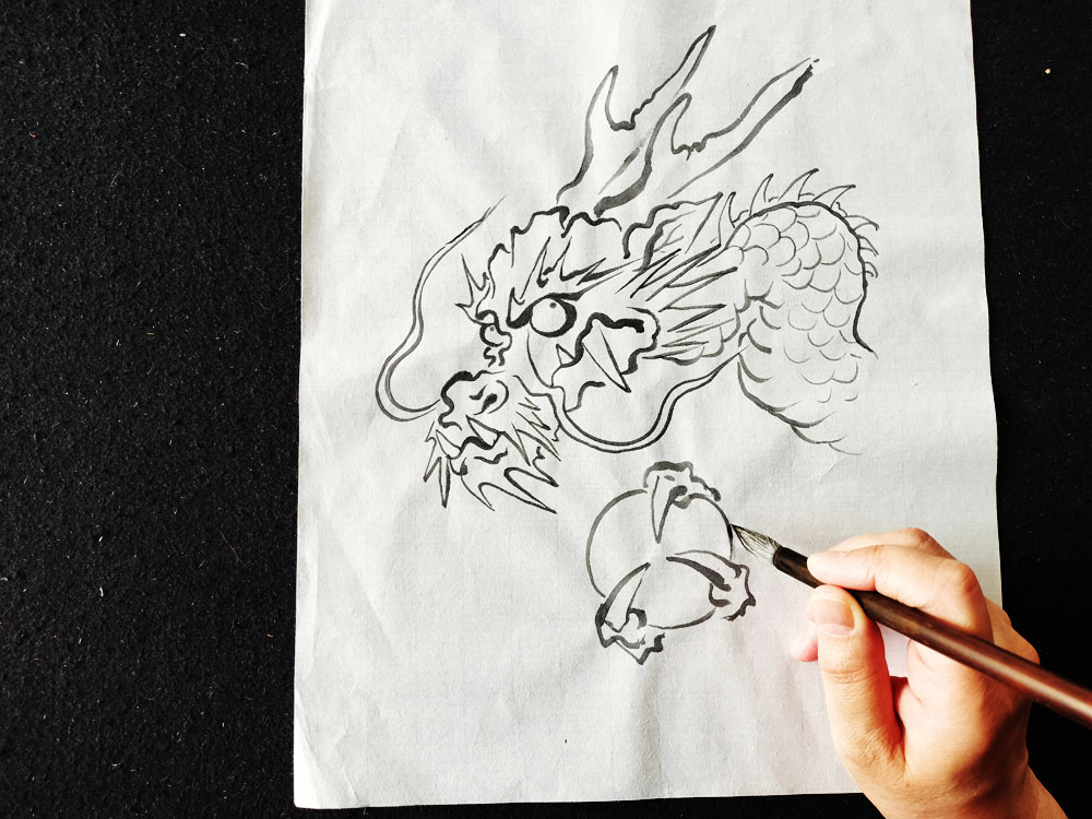 龍の顔や鱗を筆で描いている様子。初心者にも取り組みやすい龍画の作例
